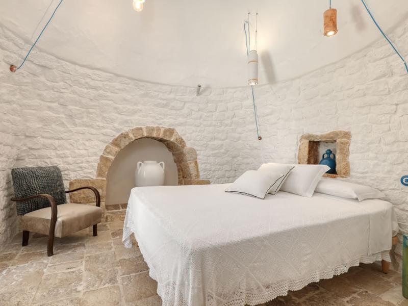 Bedroom with white stone walls and minimalist decor.