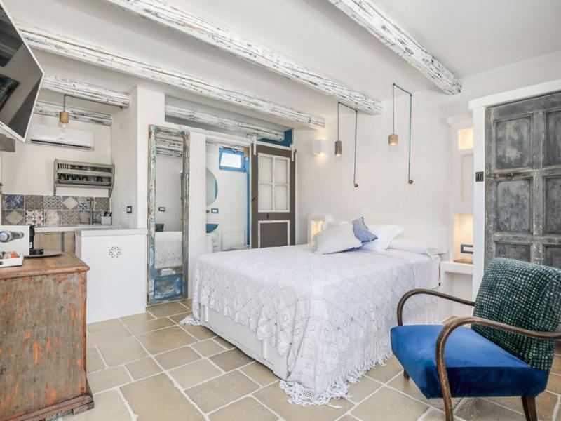 Bright bedroom with rustic and modern furnishings, decorated in Mediterranean style.