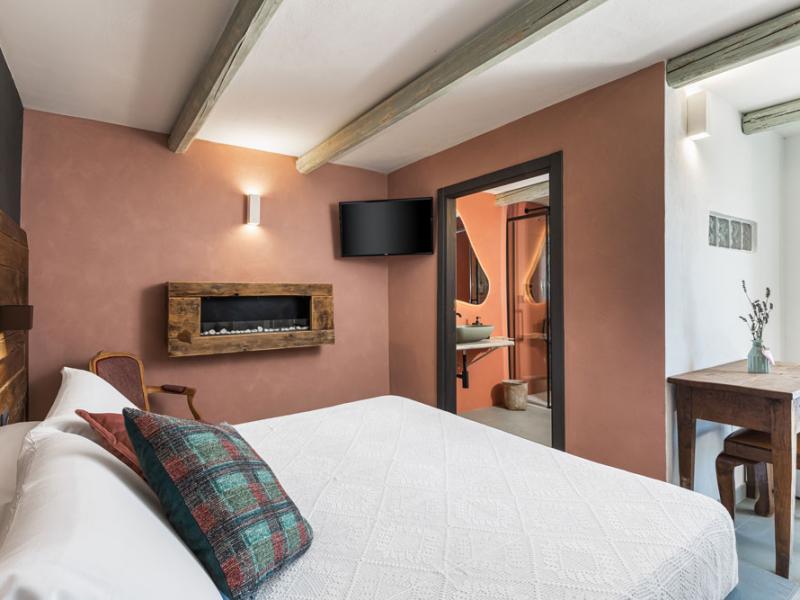 Camera accogliente con letto matrimoniale, camino e bagno moderno.